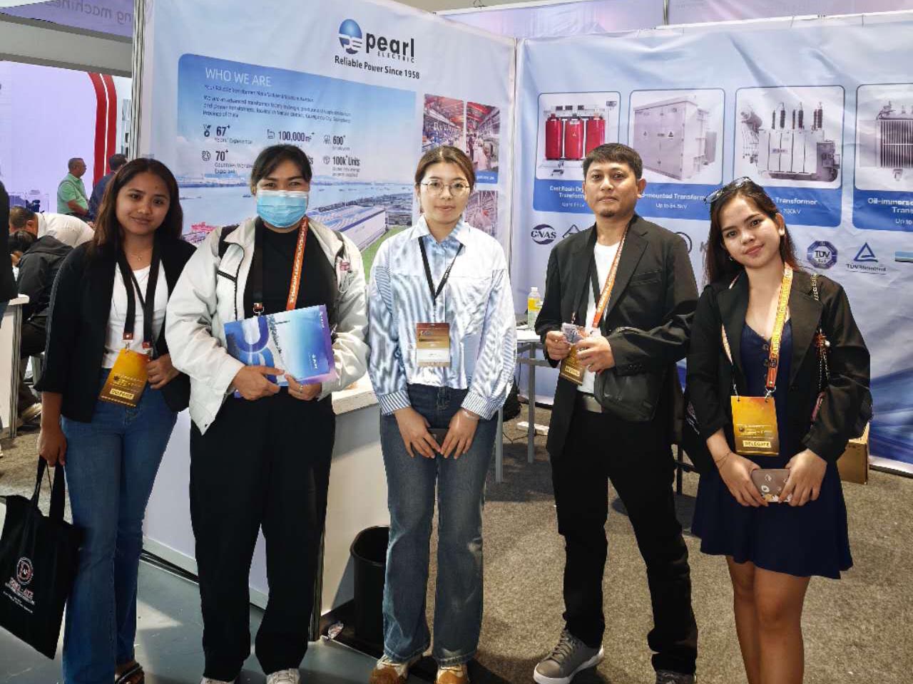 مهندس مبيعات محولات شركة Pearl Electric يقف لالتقاط صورة مع عميل من الفلبين
